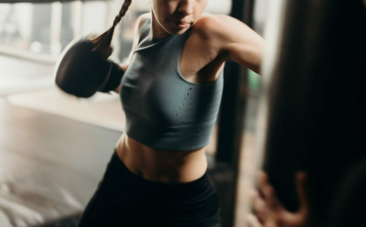 a woman in a boxing gym working out on the heavy bag