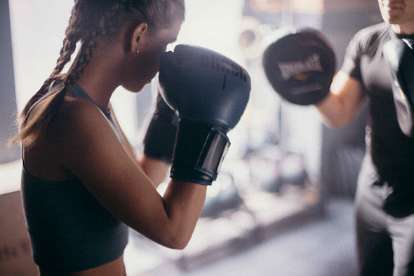 female boxing with a type a training personal trainer in a private gym