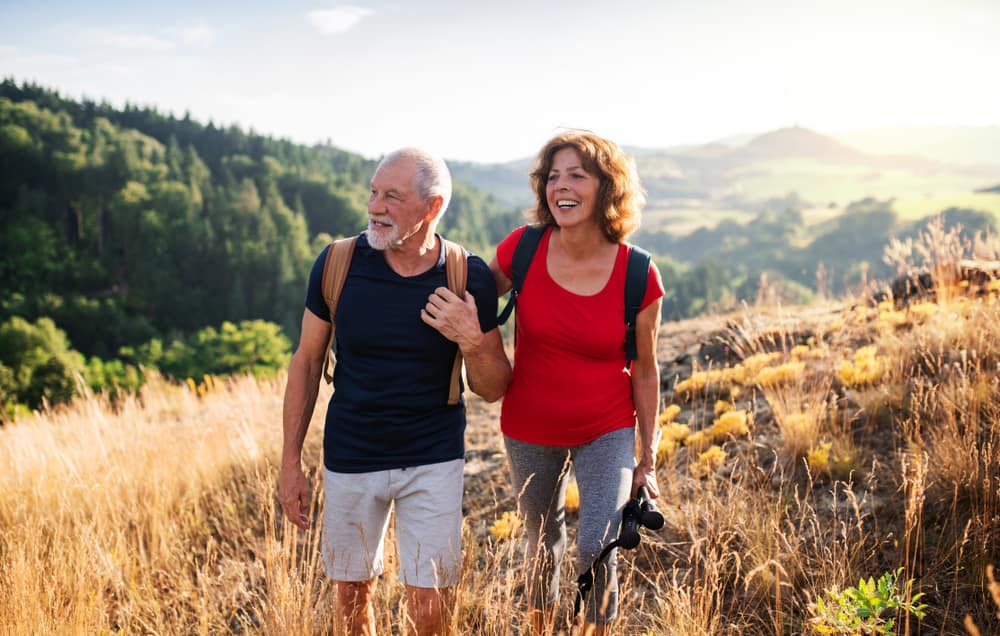 two older adults hiking on a trail