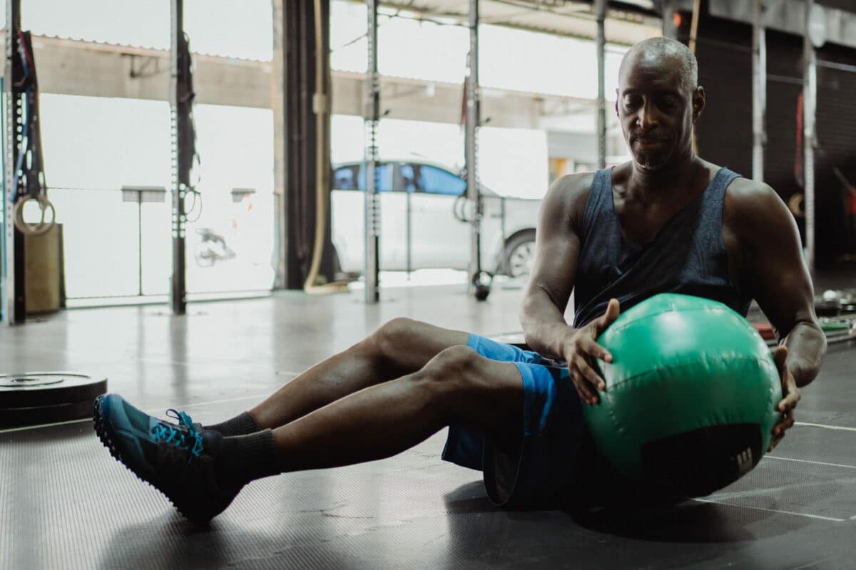 a man sitting on a floor with a ball