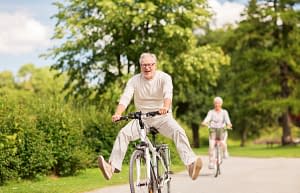 Daily Squats for Seniors, male older adult riding a bike, have fun with his partner