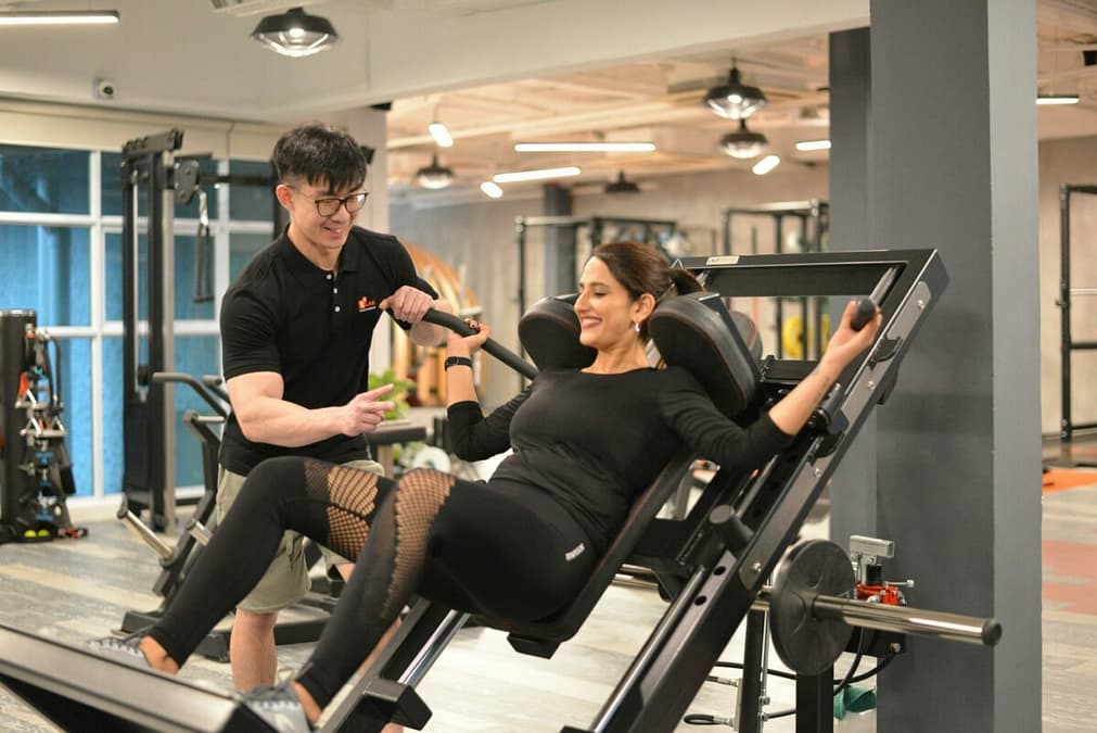 a woman on a machine with a man in the background