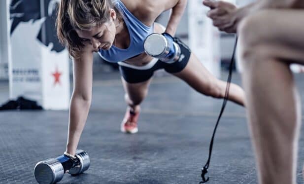 a woman doing push ups with weights