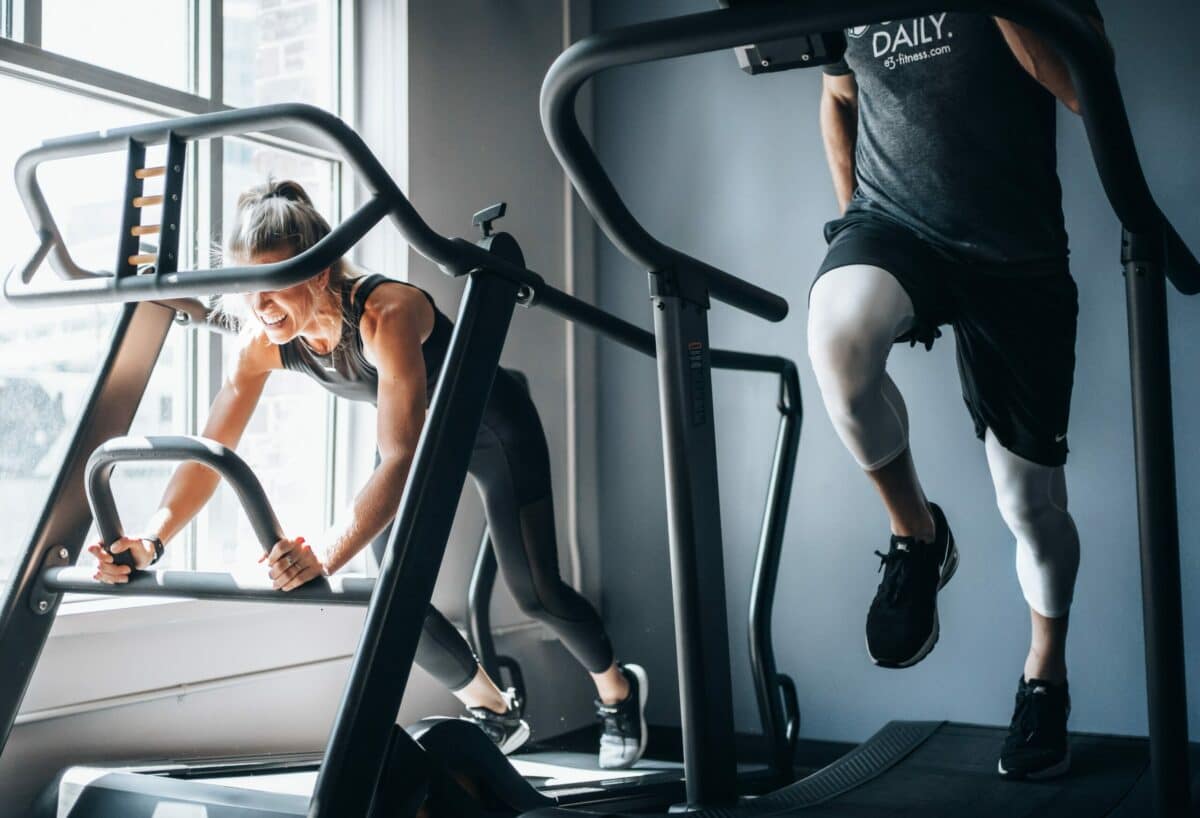 Personal trainer helping client overcome workout plateau with new exercises