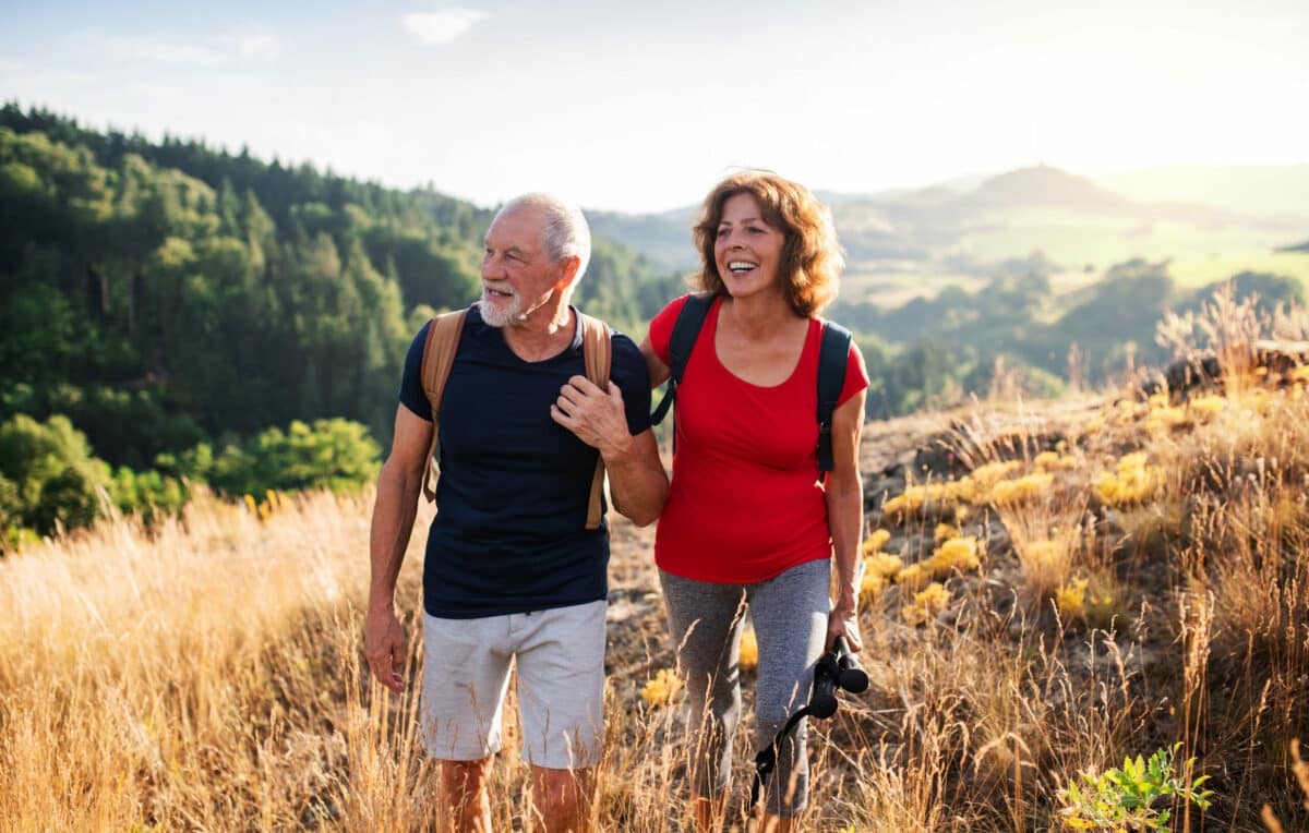 a man and woman walking on a hill