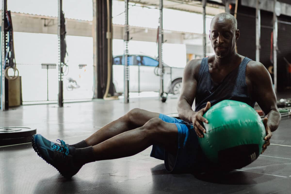 a man sitting on a floor with a ball